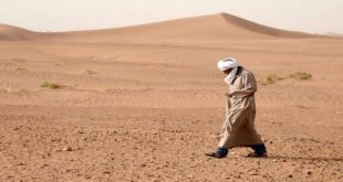 رجل يسير في الصحراء